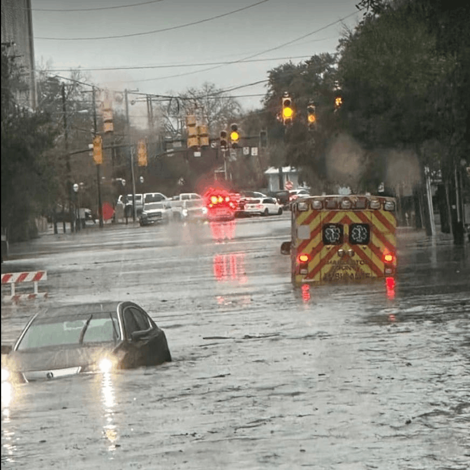 powerful flash flood waters rush down a residential street, transforming it into a fast-moving river during intense rainfall event